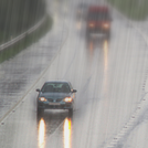 cars driving down highway in heavy rain
